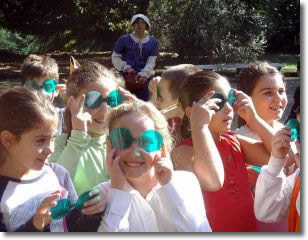 un gruppo di bambini gioca con delle maschere in un prato