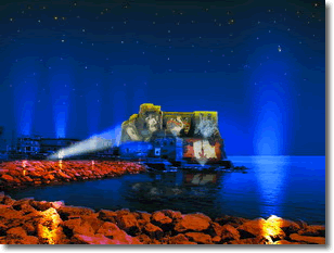 vista del castel dell'ovo di notte, illuminato da fasci di luci colorate e immagini olografiche sulle mura esterne